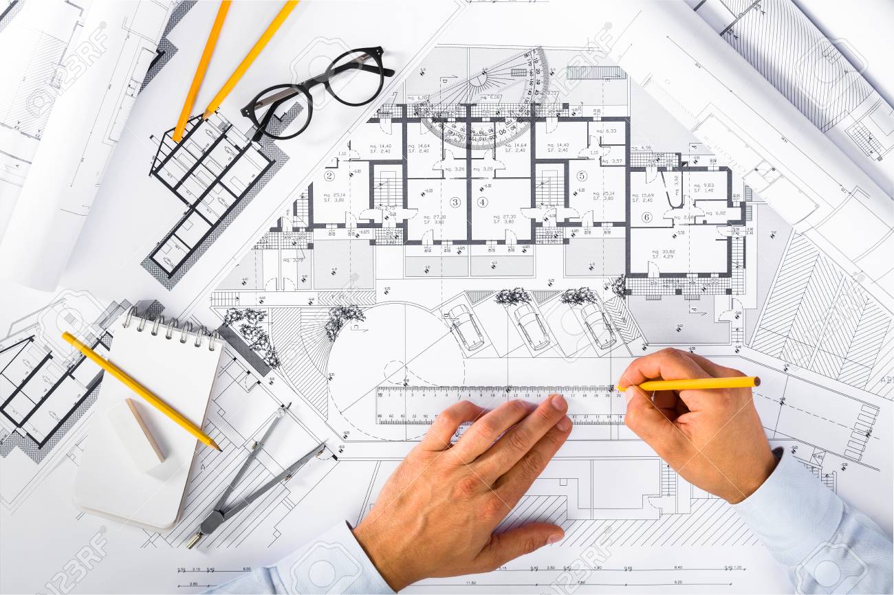 Top View of Construction plans and Male Hands drawing on blueprints; Architectural and Engineering Housing Concept.